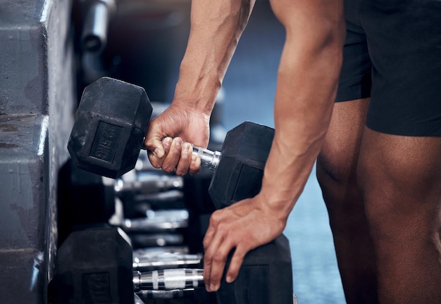 Closeup de treino de homem e levantamento de peso de mãos com halteres no ginásio para aptidão de saúde e desenvolvimento muscular Forte fisiculturista e exercício para bem-estar esportivo e motivação no clube de treinamento