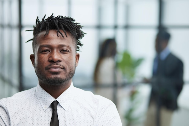 Closeup de um jovem empresário americano africano contemplando no escritório