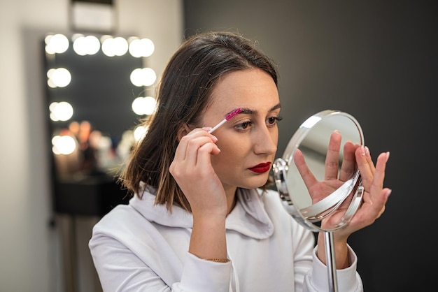 Closeup de um modelo de beleza facial feminina com pele macia fazendo tingimento de sobrancelha e laminação