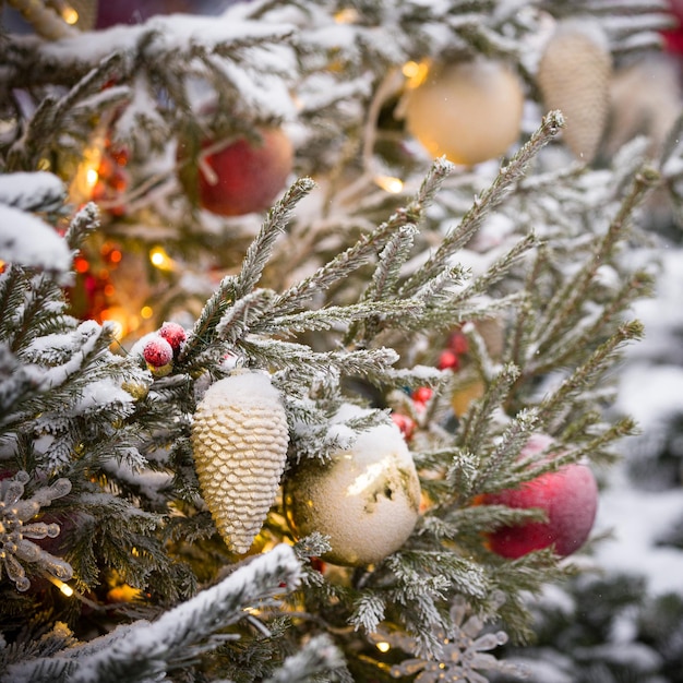 Foto closeup de uma árvore de ano novo com guirlandas brilhantes de brinquedos e neve real. conceito festivo