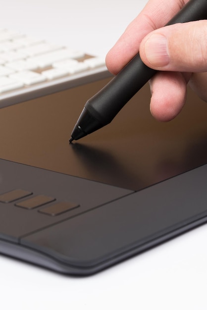 Closeup de uma mão desenhando em um tablet de computação gráfica