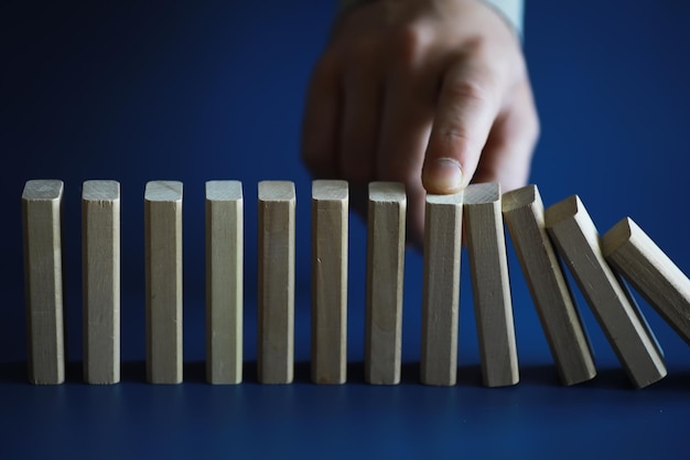 Closeup dicker Domino-Holzblock in einer Reihe stoppt das Fallen in der Krise Geschäftslösungskonzept stabil sein