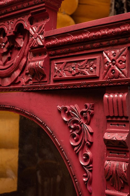 Foto closeup do antigo armário ornamentado renovado pintado na cor vermelha com paredes da casa de madeira no fundo restauração de móveis antigos em casa por si mesmo