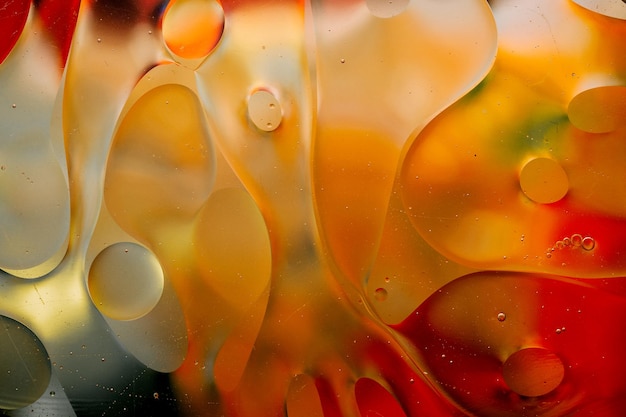 Closeup do movimento de gotas de óleo na superfície da água Macro abstrato colorido de gotas de óleo na superfície da água