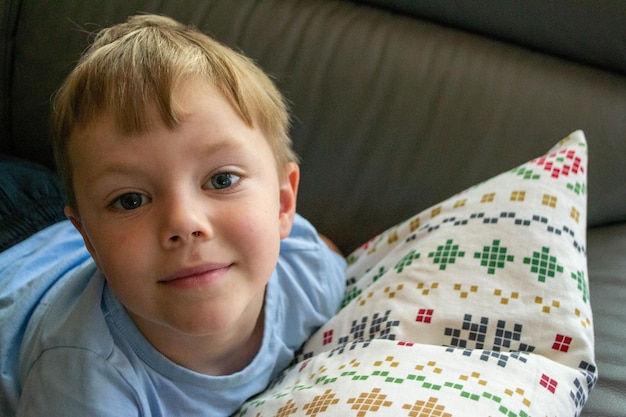 Closeup do rosto de um lindo menino de um ano deitado na cama foto de alta qualidade