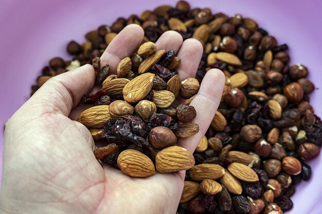 Closeup em fundo preto uvas pretas secas sem casca grandes amêndoas secas e avelãs cruas sem casca