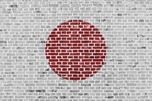 Closeup em uma parede de tijolos com a bandeira do Japão pintada nela