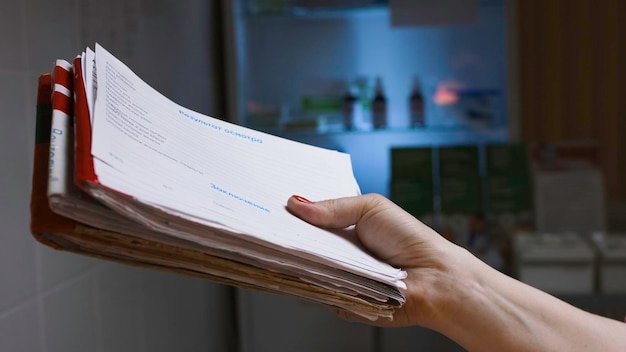 Closeup de la enfermera dando resultados de exámenes y pruebas en el fondo oscuro del hospital