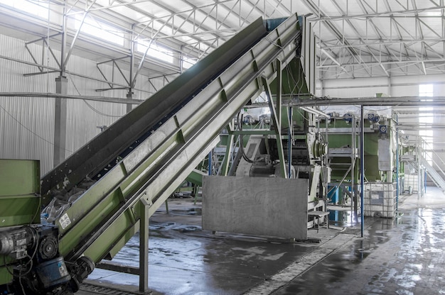 Closeup escalera mecánica en la fábrica para el procesamiento y reciclaje de botellas de plástico Reciclaje de PET