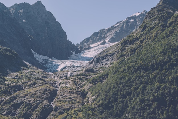 Foto closeup exibição de cenas de montanhas no parque nacional dombai, cáucaso, rússia, europa. paisagem de verão, clima ensolarado, céu azul dramático e dia ensolarado