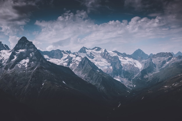 Closeup exibição de cenas de montanhas no Parque Nacional Dombai, Cáucaso, Rússia, Europa. Paisagem de verão, clima ensolarado, céu azul dramático e dia ensolarado