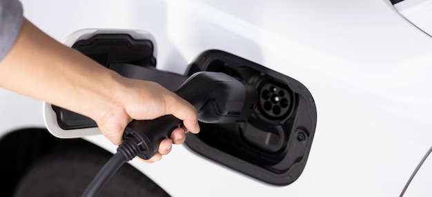 Closeup Focus Hand stecken EV-Ladegerät in progressive elektrische wiederaufladbare Auto