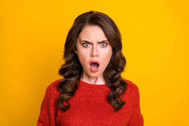 Closeup foto de atraente cacheada chocada senhora boca aberta ouvir más notícias quarentena corona vírus continuar a usar suéter de malha vermelha isolado fundo de cor amarela