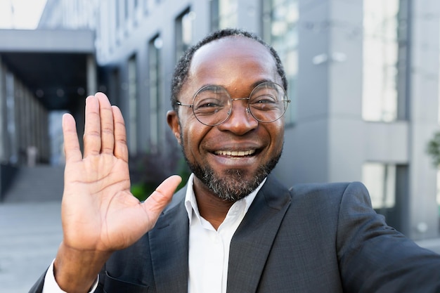 Closeup foto de um homem afro-americano feliz, um empresário conversando com sua equipe por meio de uma videochamada