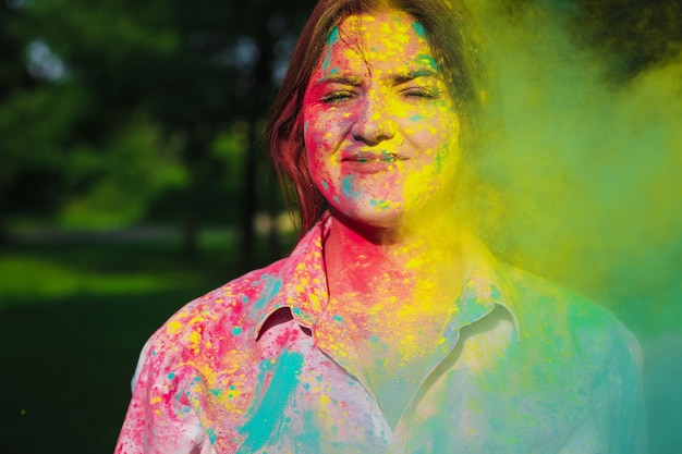 Closeup foto de modelo caucásico feliz jugando con pintura seca amarilla en el Festival de Holi. Espacio vacio