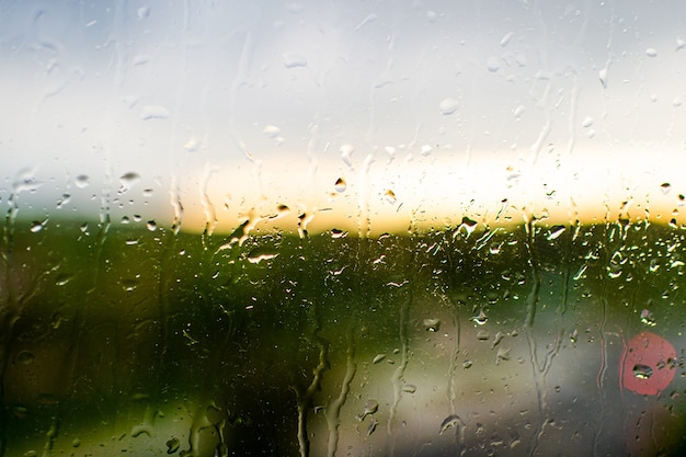 Closeup gotas de lluvia sobre la superficie de la ventana brillante
