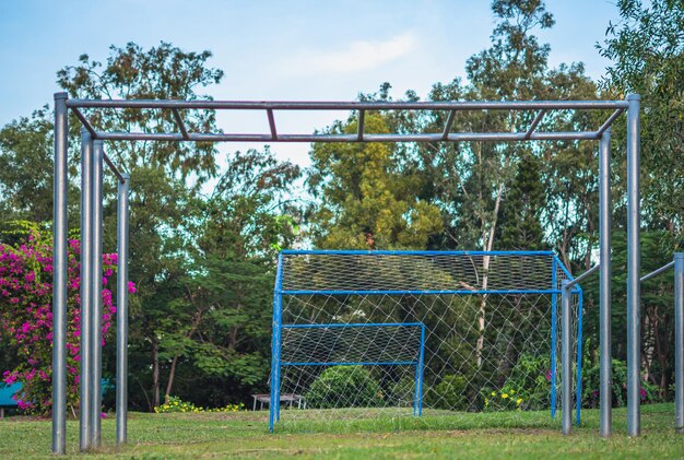 Closeup große hohe Metall leere Klimmzugstange im Freien zum Aufwärmen des Sports vor dem Spielen in der Nähe des Fußballtors Sommerhimmel Waldpark Blume Sporterziehung zur Motivation der Entwicklung an der frischen Luft