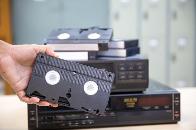 Closeup Hand wählt Videokassette VHS alten Retro-Stil und drücken Sie die Taste auf Video-Record-Wiedergabe-Konzept von alten elektrischen und elektronischen Geräten Multimedia-Player-Gerät altmodisch
