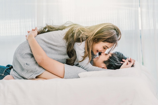 Closeup Happy Asian Lover küsst und umarmt auf dem Bett im Schlafzimmer