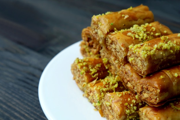 Closeup Haufen von köstlichem Baklava Gebäck mit Pistazien auf einem weißen Teller