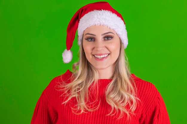 Closeup Hermosa joven Santa Claus con sombrero de Santa sonriendo a la cámara en el fondo verde