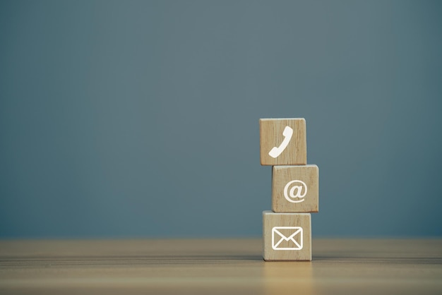 Closeup Holzblockwürfel mit Symbol E-Mail-Adresse Telefon auf Holztisch