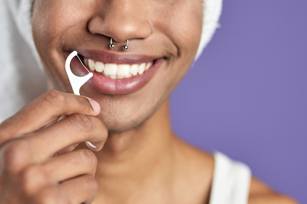 Closeup homem transgênero com fio dental sorrindo sobre fundo roxo afroamericano transgênero