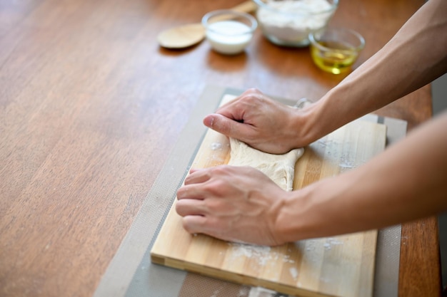 Closeup imagem da mão de um padeiro masculino amassando massa crua preparando massa para sua massa