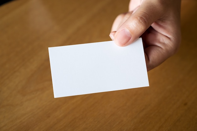 Closeup imagem de mãos segurando e dando um cartão vazio para alguém na mesa