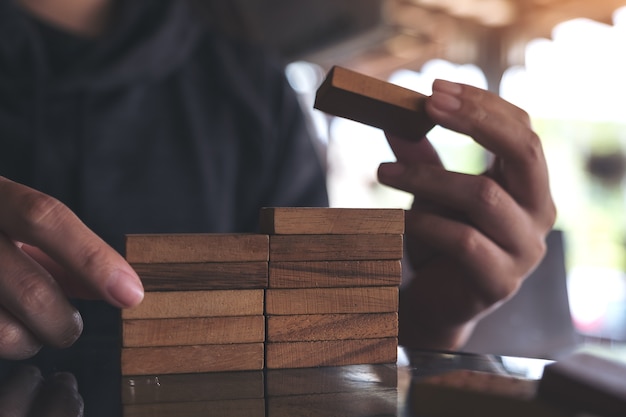 Closeup imagem de pessoas jogando e construindo jogo de quebra-cabeça de madeira