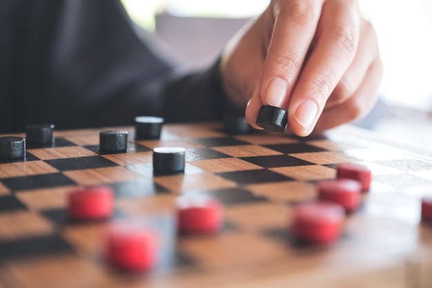 Foto closeup imagem de pessoas jogando e se movendo damas em um tabuleiro de xadrez