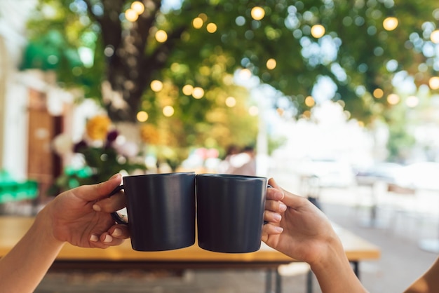 Foto closeup imagem de um povo tilintando xícaras de café juntos no café