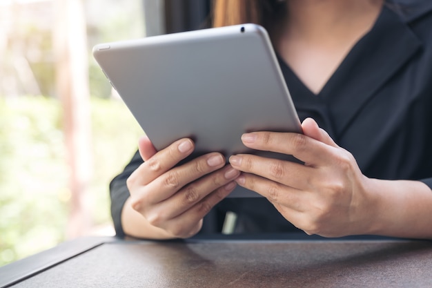 Closeup imagem de uma mulher segurando e usando o tablet pc no café moderno