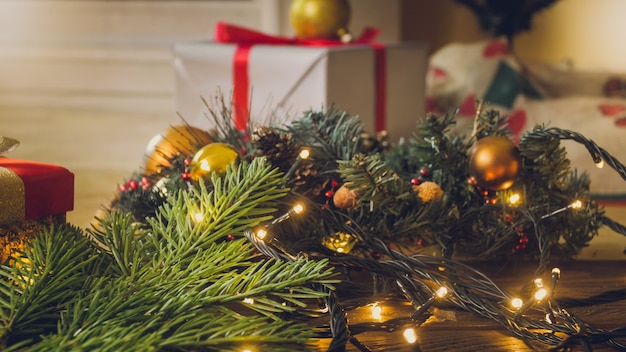 Closeup imagen de brillantes luces de Navidad y cajas de regalo con cintas bajo el árbol de Navidad