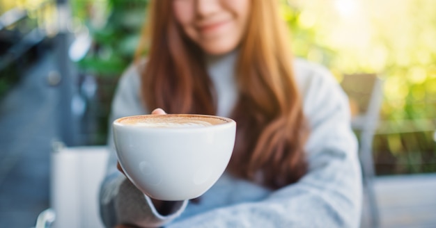 Closeup imagen de una hermosa mujer asiática sosteniendo una taza de café caliente