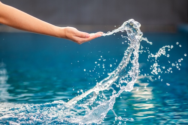 Closeup imagen de una mano salpicando agua en la piscina