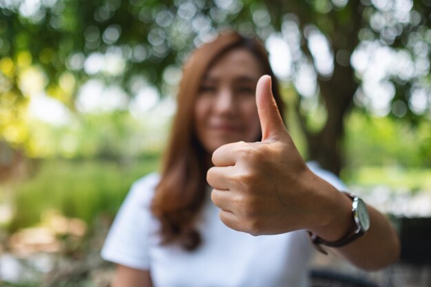 Closeup imagen de una mujer haciendo y mostrando Thumbs up hand sign