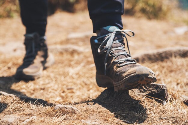 Closeup imagen de una mujer de senderismo con botas de trekking en la cima de la montaña