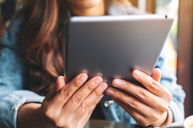 Closeup imagen de una mujer sosteniendo y usando tablet pc