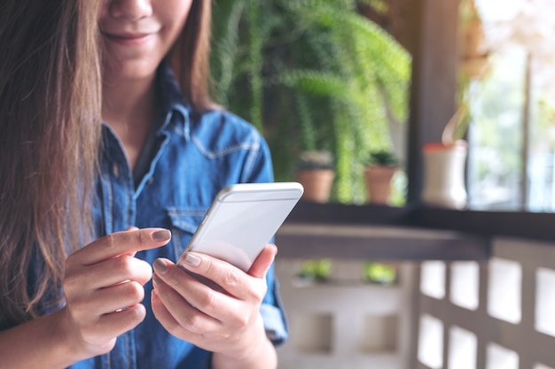 Closeup imagen de una mujer sosteniendo, usando y tocando un teléfono inteligente