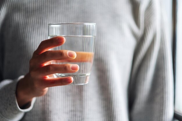 Closeup imagen de una mujer sosteniendo un vaso de agua pura