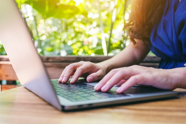 Closeup imagen de una mujer trabajando y escribiendo en la computadora portátil sobre la mesa