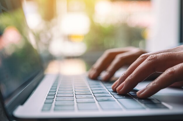 Closeup imagen de una mujer trabajando y escribiendo en el teclado de la computadora portátil