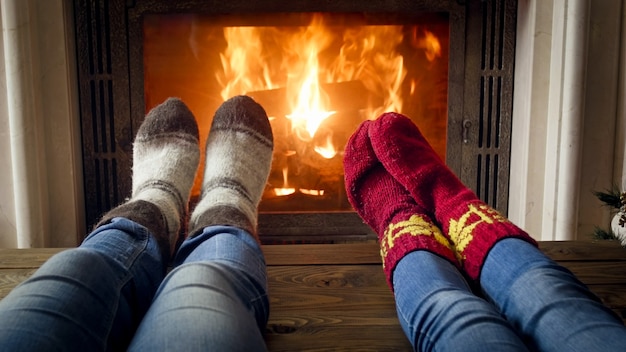 Closeup imagen de pareja en jeans y calcetines de lana junto a la chimenea