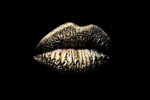 Closeup labios dorados mujer sexy maquillaje de labios dorados aislado sobre fondo negro