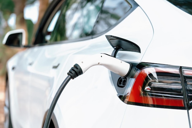 Closeup-Ladegerät für Elektroautos, das mit alternativer und nachhaltiger Energie mit null CO2-Emissionen für eine saubere Umwelt angeschlossen oder mit einem Elektroauto verbunden ist