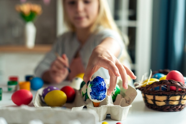 Closeup mano femenina sostiene un huevo azul. Centrarse en el huevo. Preparándose para la Pascua