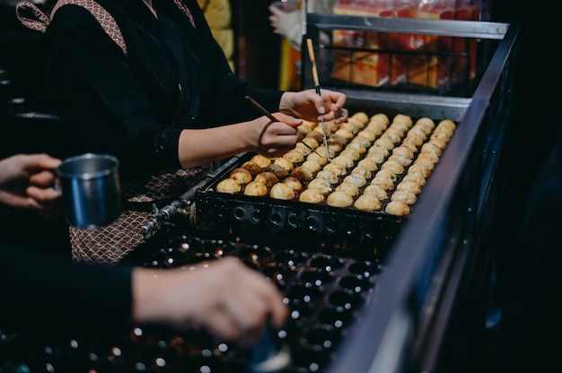 Closeup mano haciendo takoyaki. Takoyaki es una bola merienda japonesa merienda popular.