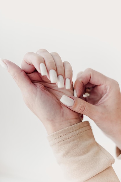 closeup de las manos de una mujer joven recibiendo la lima de uñas por un esteticista en el salón de belleza