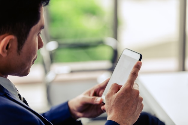 Closeup mão sian empresário sorriso trabalho feliz relaxamento com smartphone no escritório